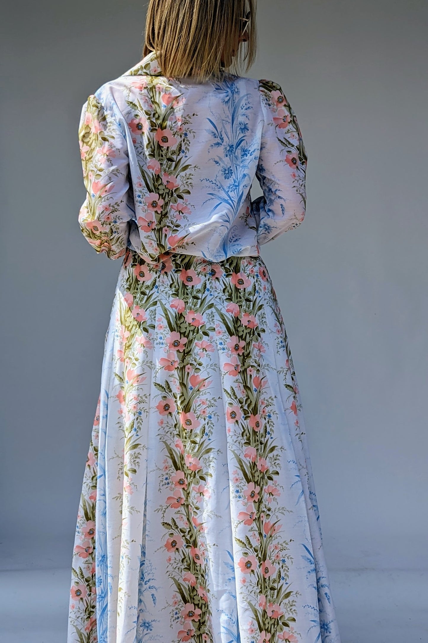 back of 70s vintage two piece floral skirt summer suit with long sleeve blouse and maxi skirt in pinks and blues on white