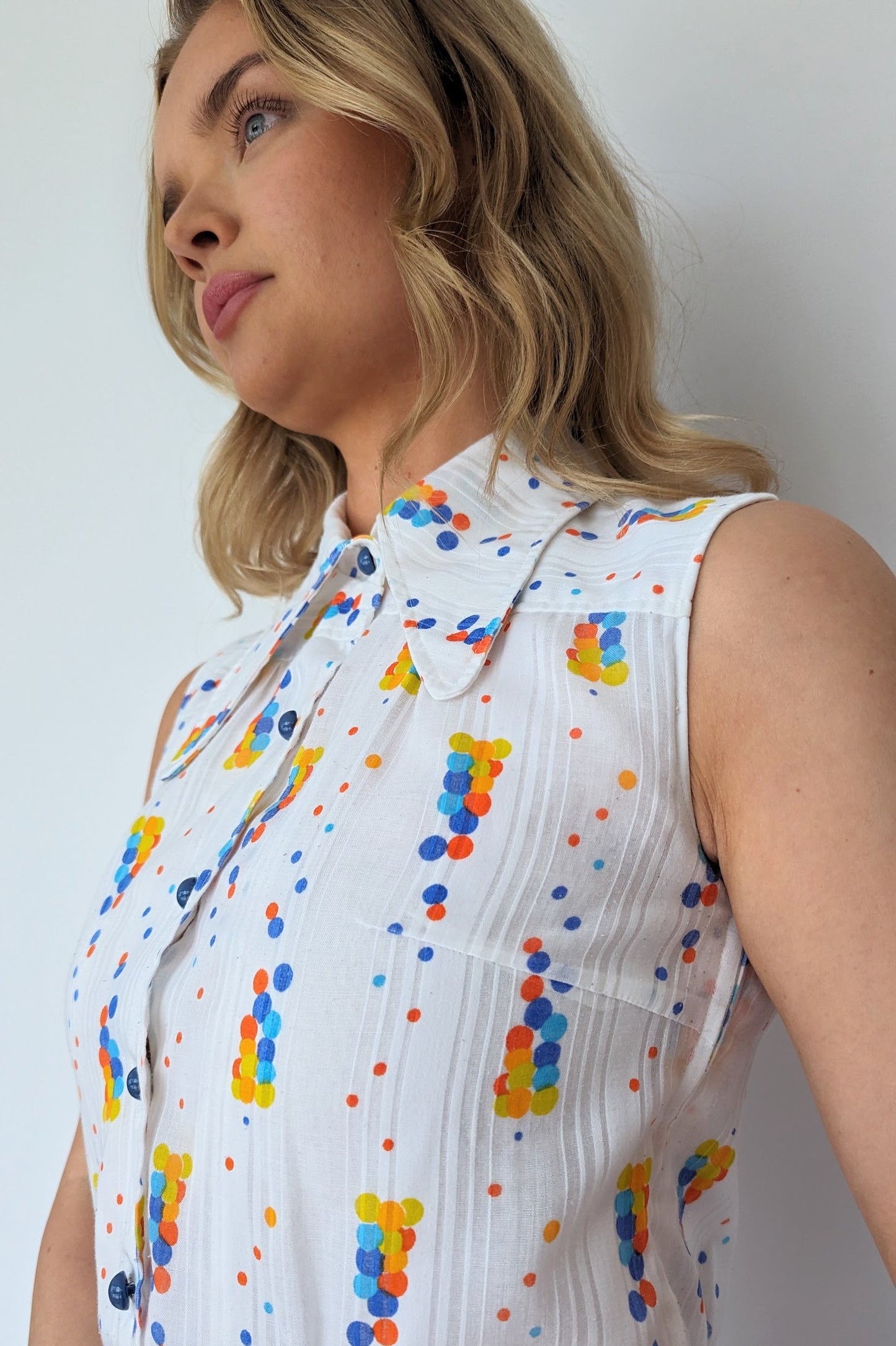 top of dress from 60s showing dagger collar and white fabric with blue, yellow and orange spots