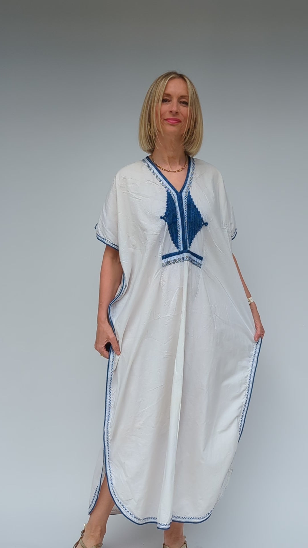 video showing large kaftan dress in white with blue trim