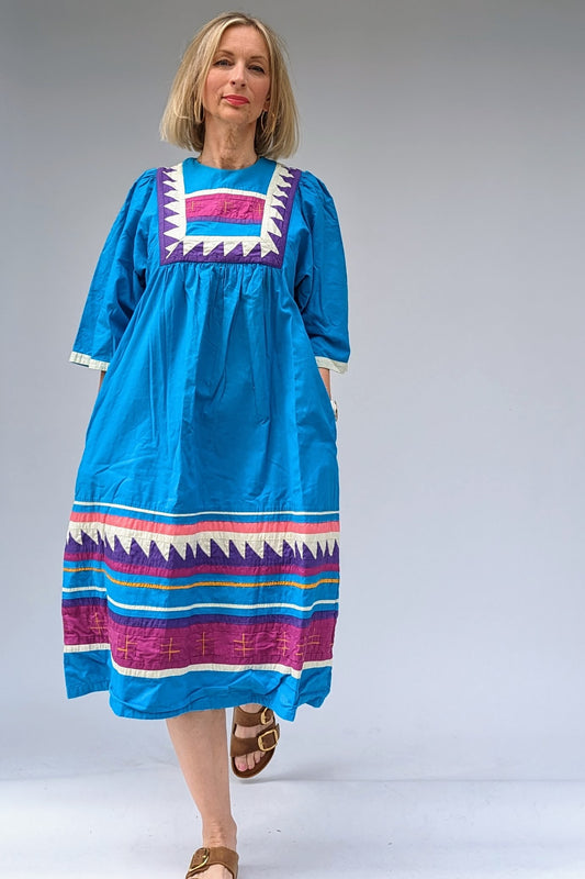 Blue, pink and purple patchwork folk dress with round colour, kimono sleeves and geometric pattern and pockets